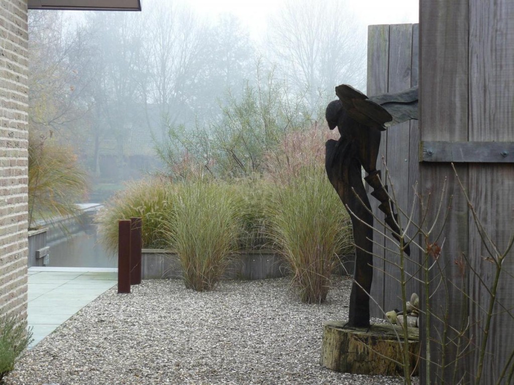 Laaghangende mist zorgt voor mystiek in deze moderne tuin aan het water 