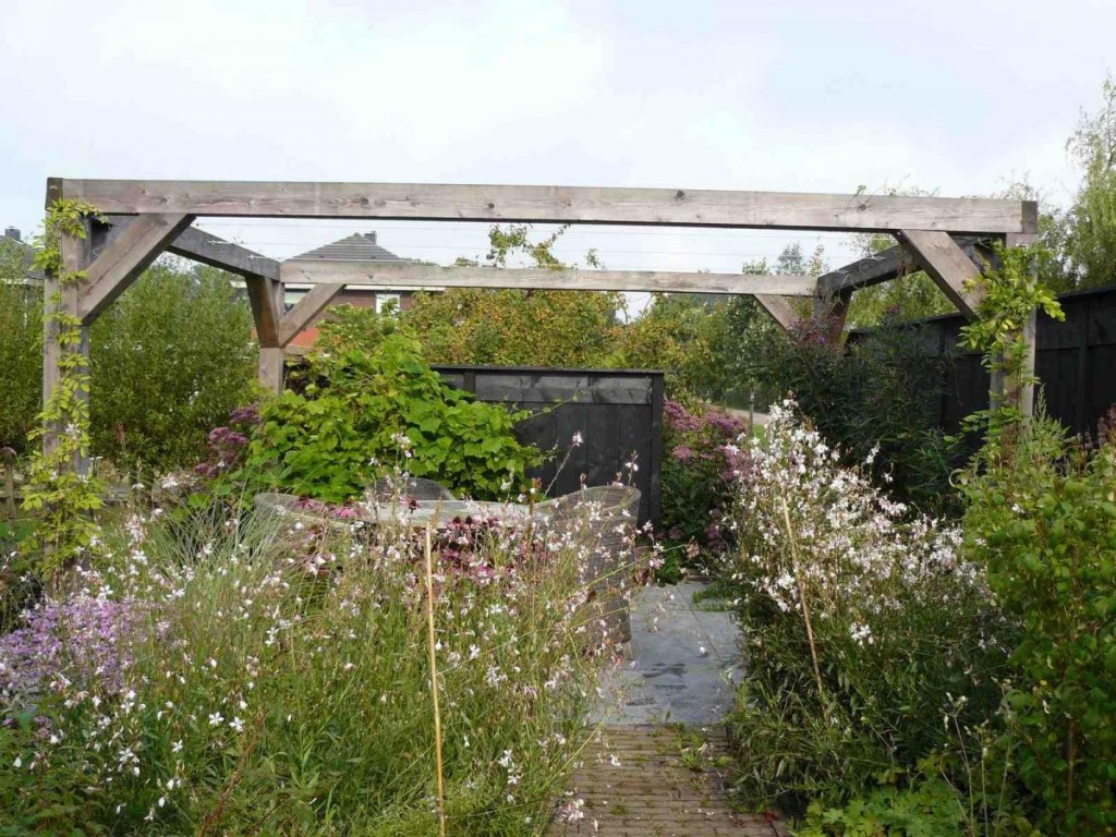 robuuste pergola en rustiek zwarte schutting